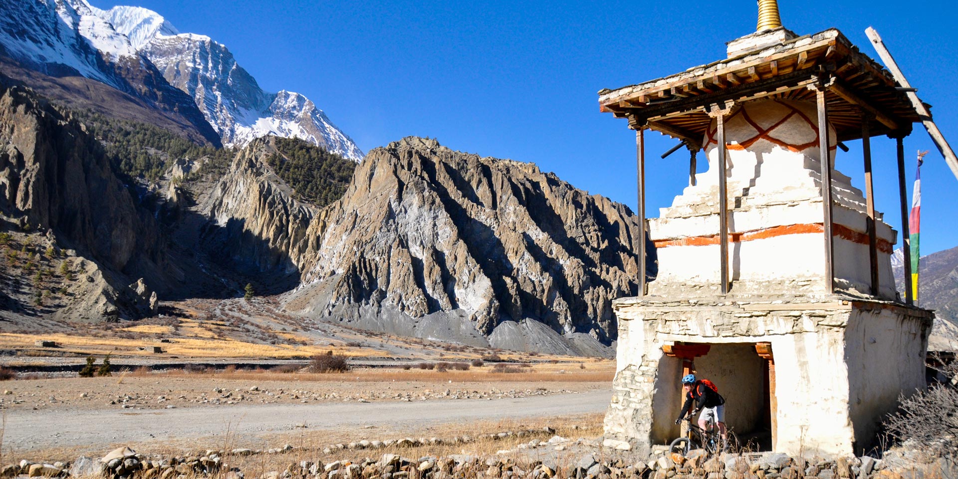 Mountain biker going through an entrace chorten at Braga in the Manang valley of the Annapurna Circuit in Nepal